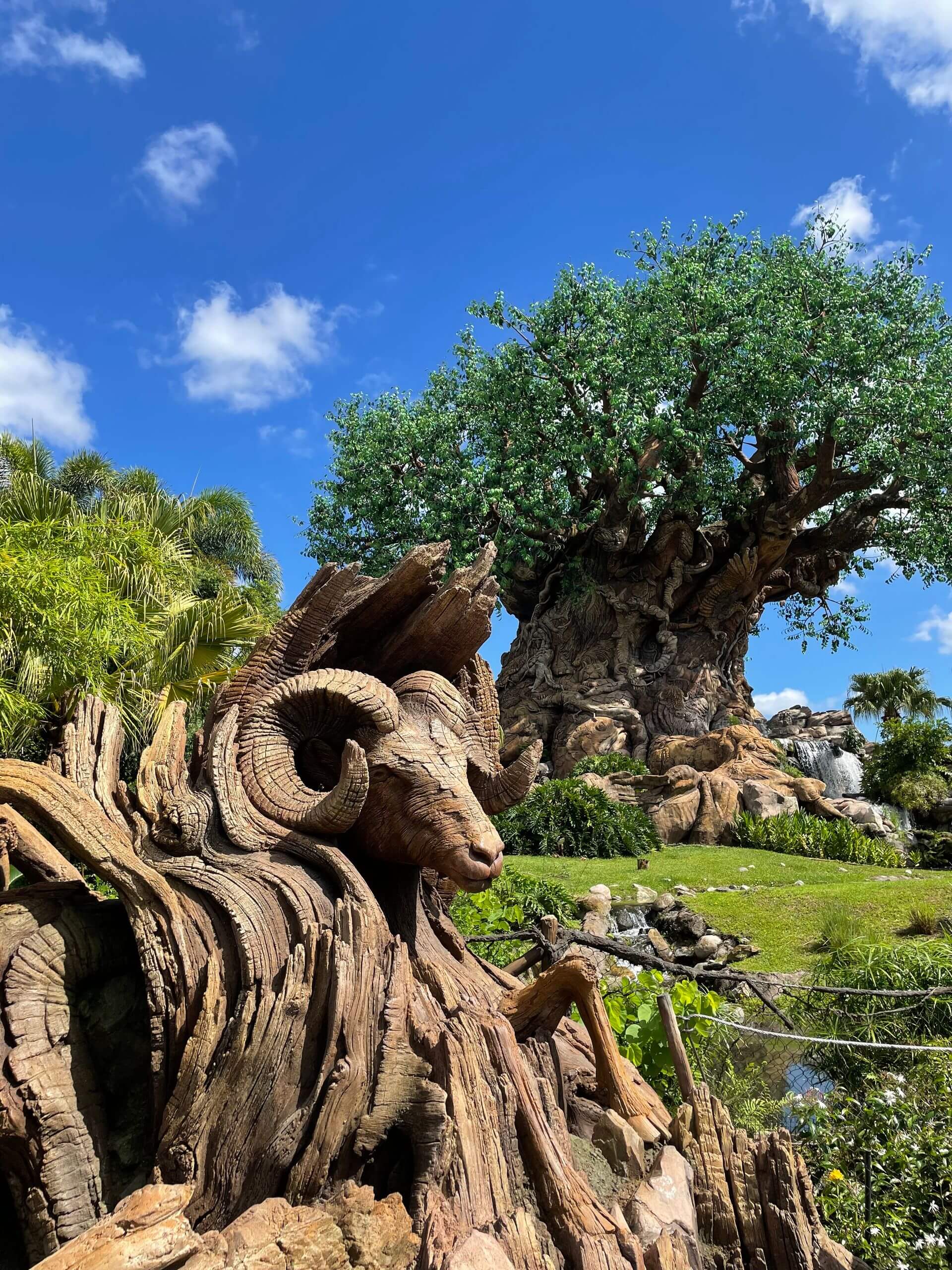 Stunning view of the Tree of Life sculpture under a bright blue sky at a park in Orlando, Florida.